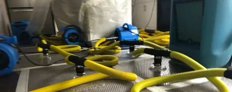 Floor drying mats and air movers working on a wet Framingham floor